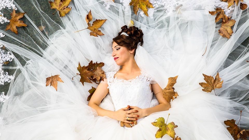 bride surrounded by autumn leaves