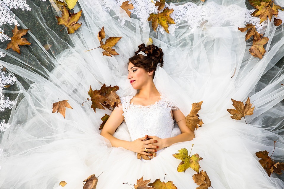 bride surrounded by autumn leaves