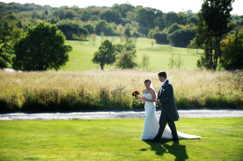 Groom and bride walking by Crondon Park