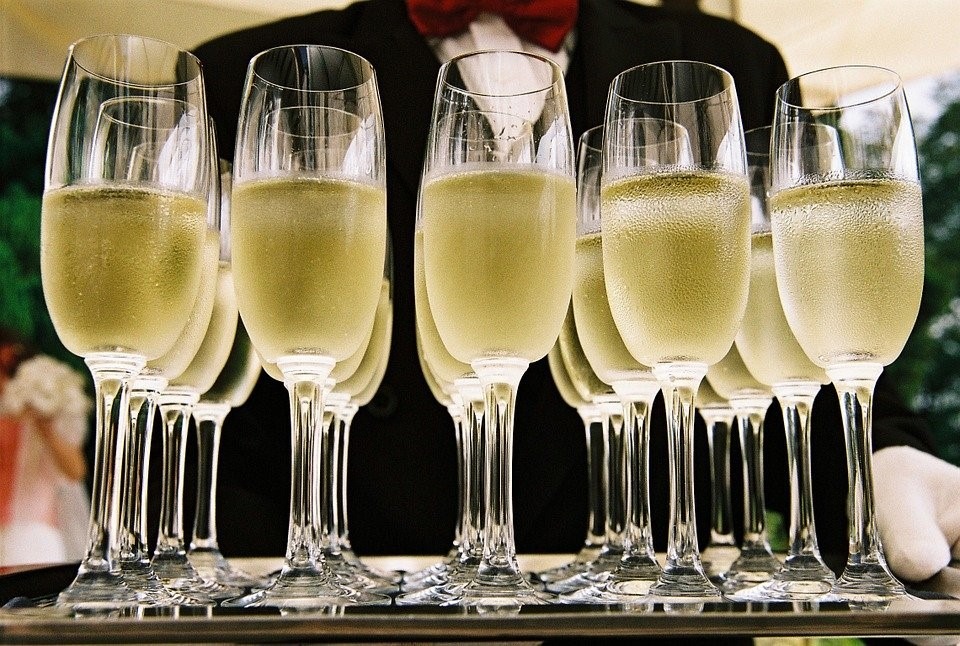 Champagne in flutes in serving tray held by waiter