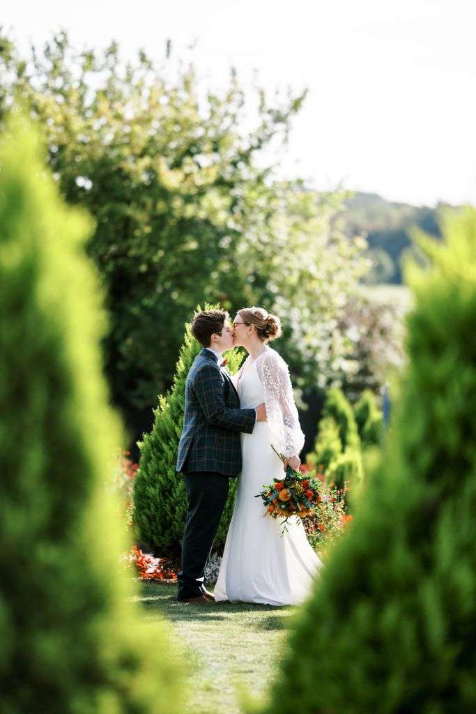 Brides share a kiss in the garden 